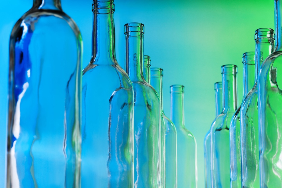 Stock image of clear glass bottles on a blue and green background