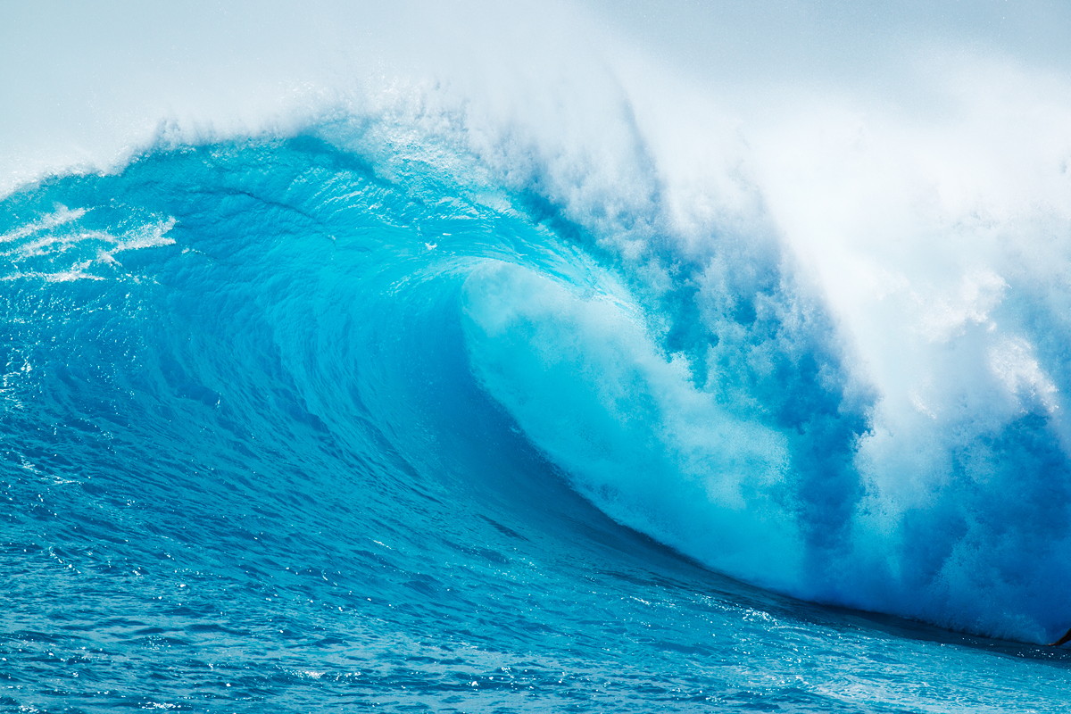 A large wave in the ocean of clean blue water which is what the ocean actually looks like (clean and not polluted)